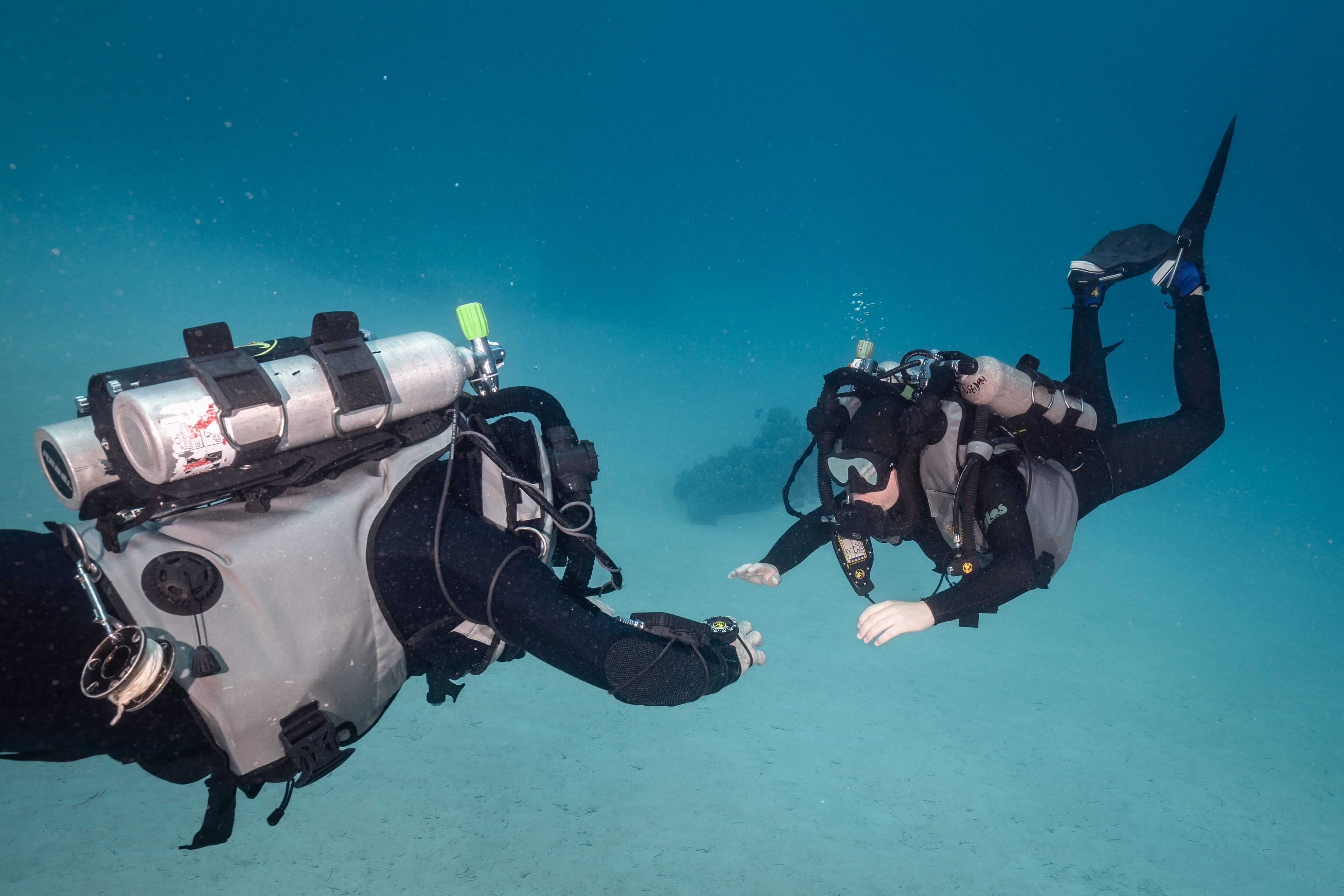 Technical divers using Nitrox-compatible diving equipment during a liveaboard dive to support longer bottom times and repetitive diving.