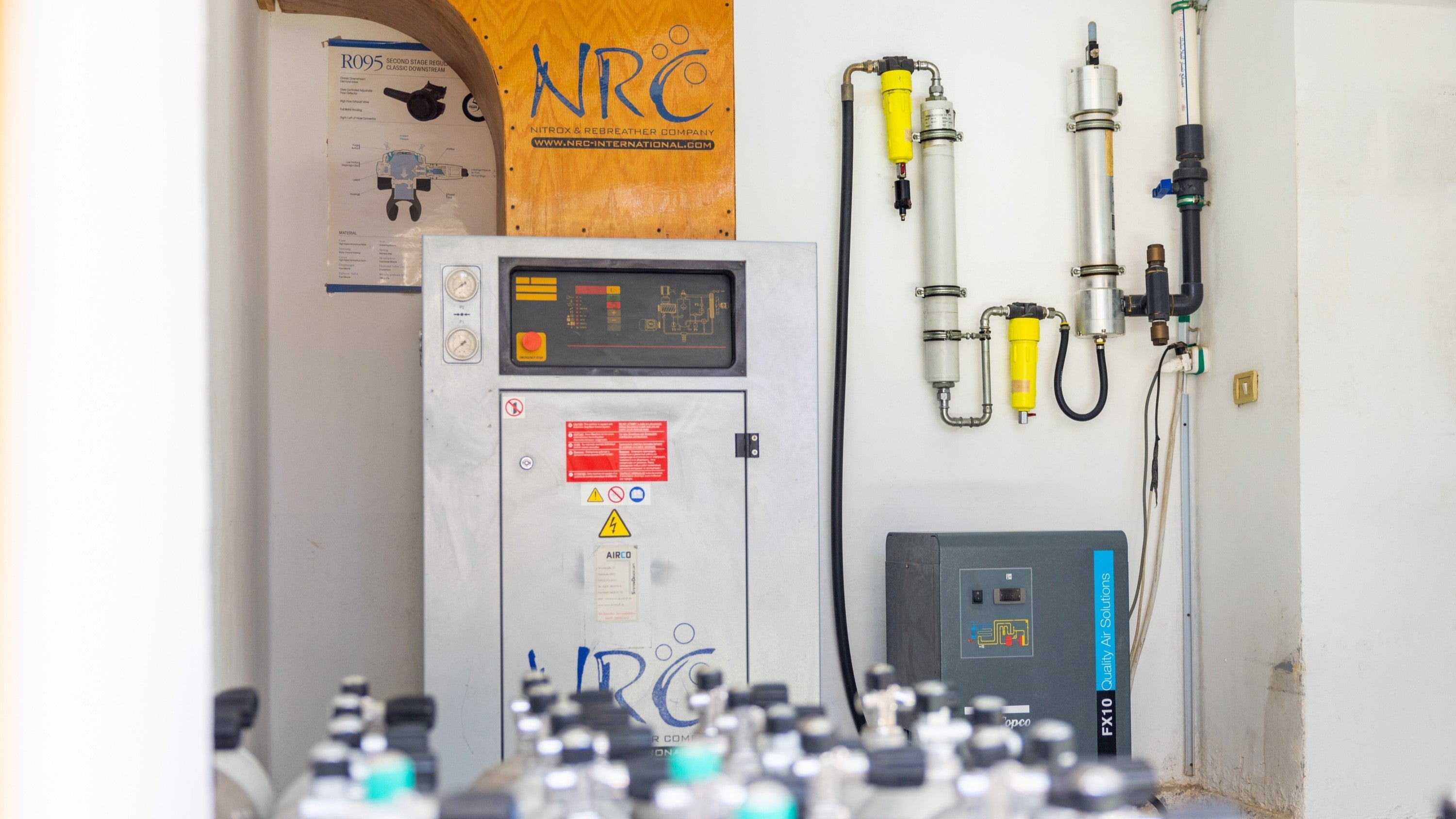 NRC Nitrox membrane system separating nitrogen from ambient air to produce enriched oxygen gas for scuba diving cylinders inside a dive center’s gas room.