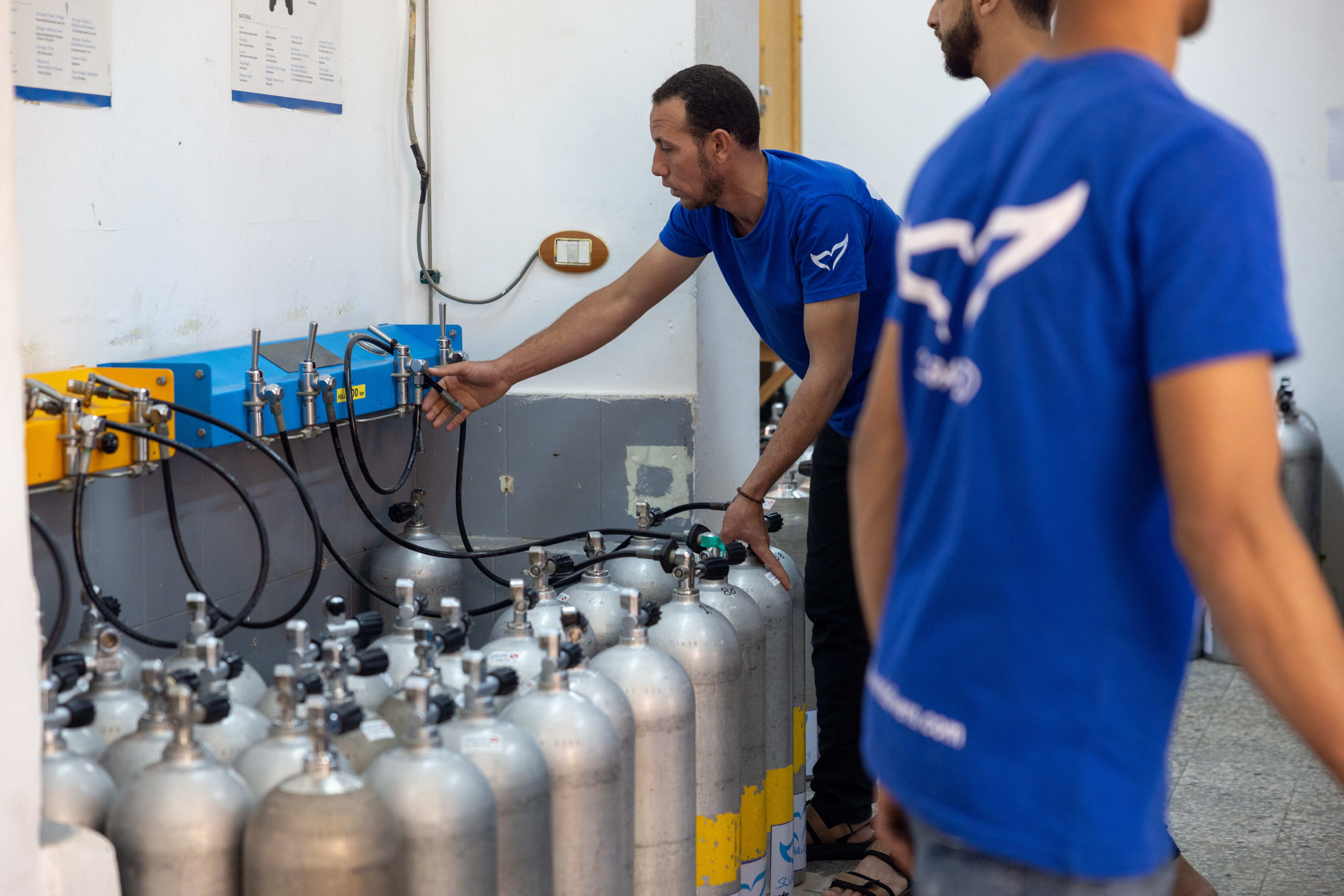 man filling scuba tank in dive center and liveaboard