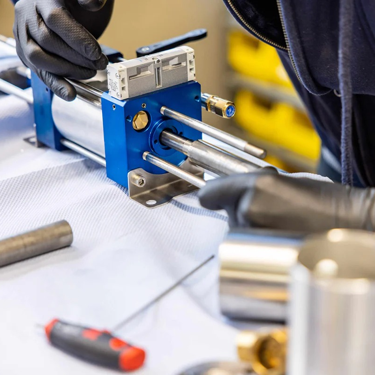 Technician assembling an NRC TEC Booster pump, showing precision-built components used for compressing oxygen and helium in technical diving