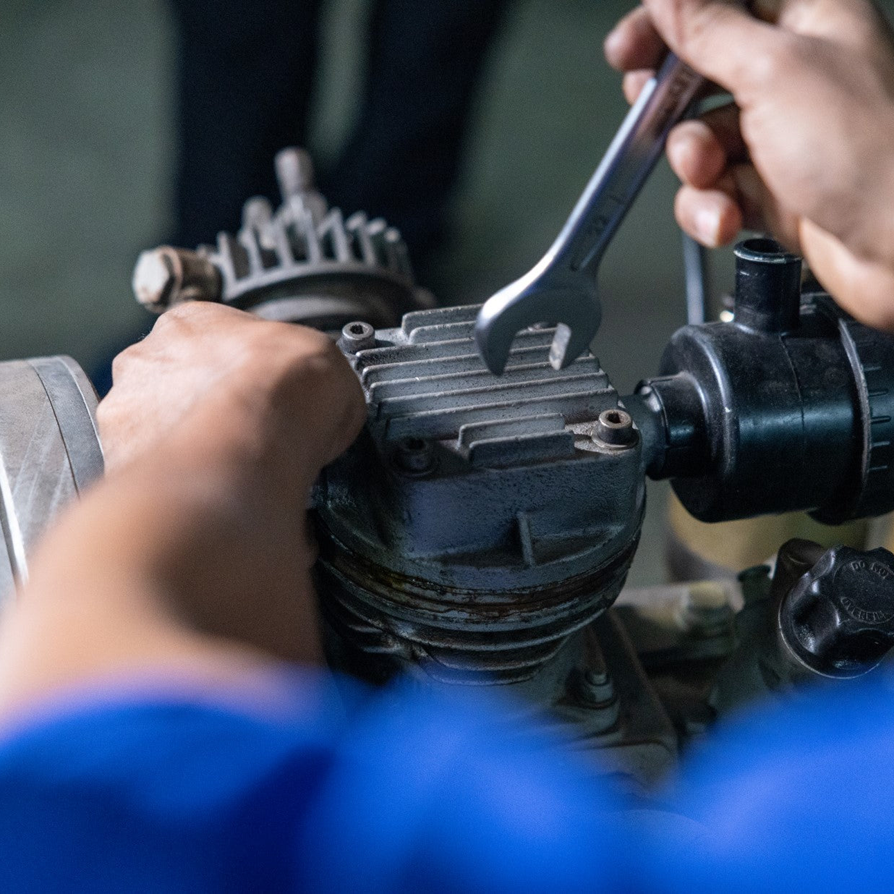 Technician servicing a high-pressure compressor unit, ensuring reliable air compression for diving operations.