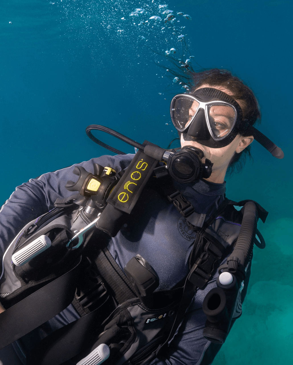 Diver underwater using an ENOS transponder attached to the harness for enhanced surface-location safety.
